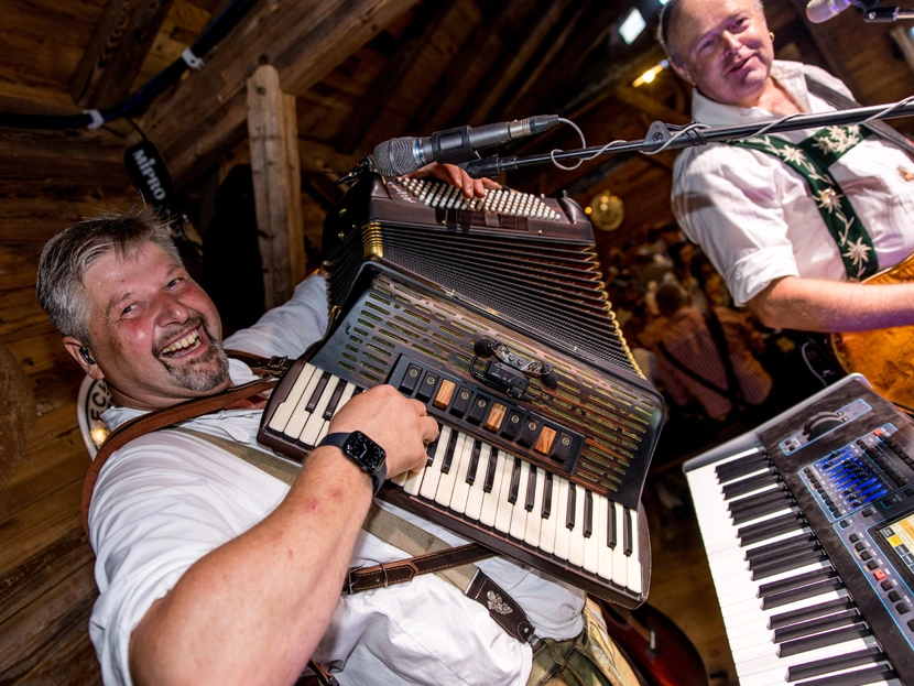 Bühne mit Musik und feiernden Gästen in einem Festzelt